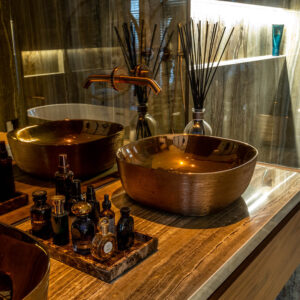 Koperen opzetwastafels op een marmeren wastafelmeubel