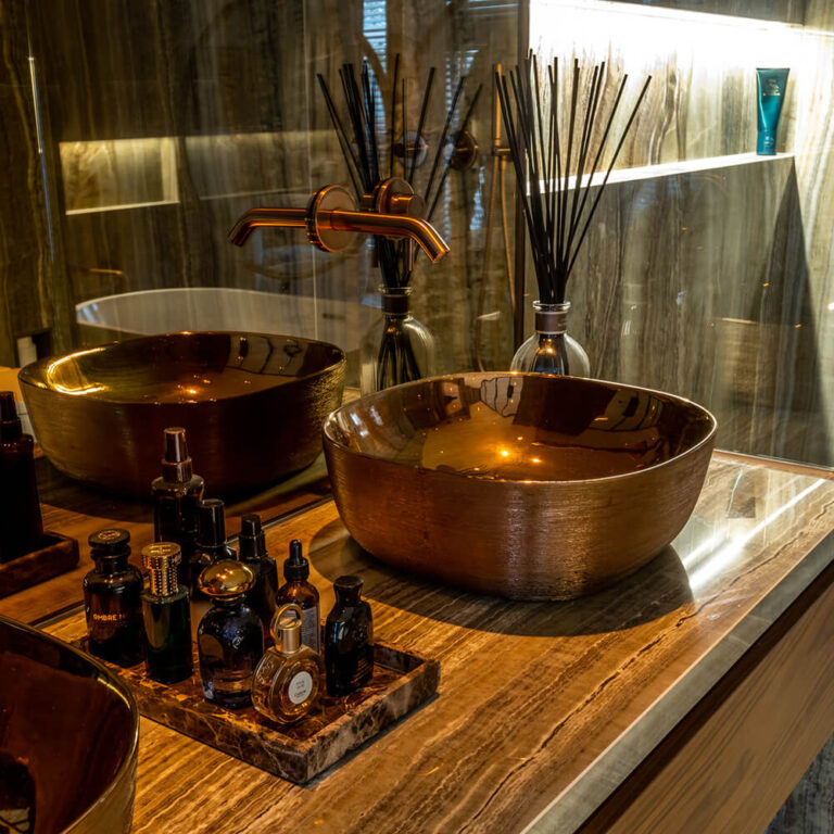 Koperen opzetwastafels op een marmeren wastafelmeubel