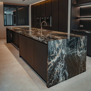 Modern marmeren keukeneiland met donkere kasten